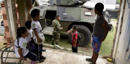 Tanks står foran ei gruppe barn i Colombia. Pengane frå Operasjon Dagsverk går til arn og unge i Colombia.